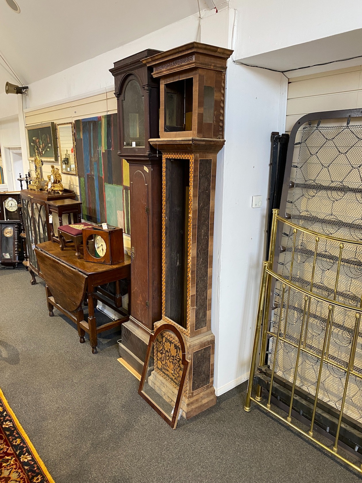 A George III oak longcase clock case and an inlaid clock case, larger 222 cm high.